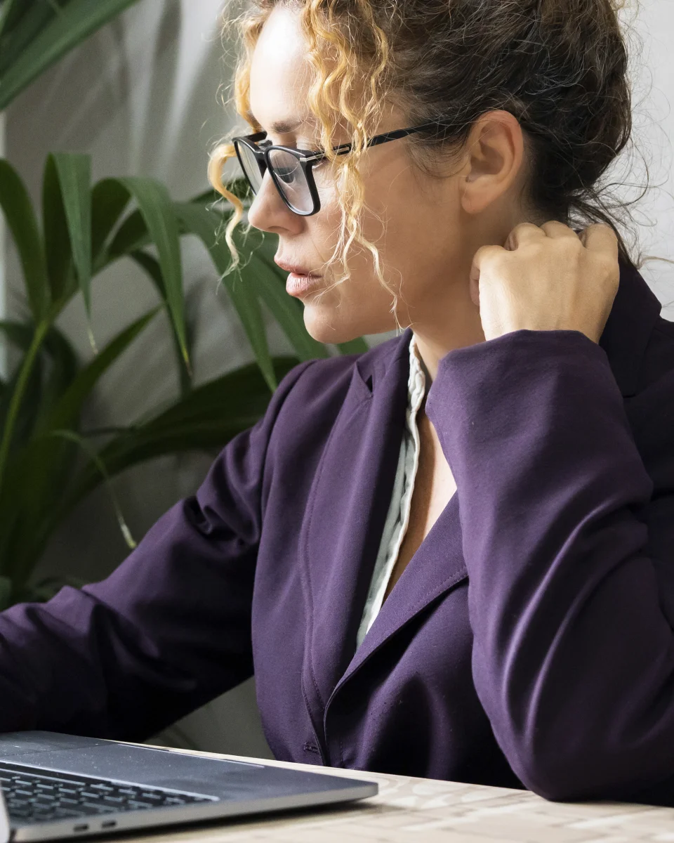 A professional working on a laptop in a bright office
