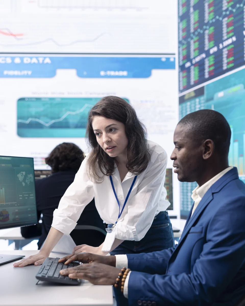 Two colleagues working through a process at a shared workstation