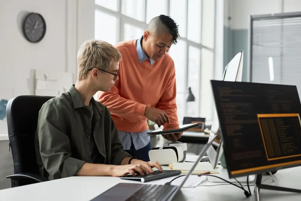 Software developers reviewing code together at a workstation