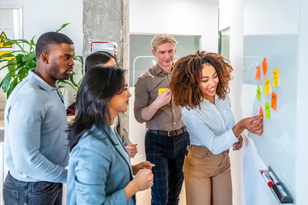 A team planning together with sticky notes on a glass wall