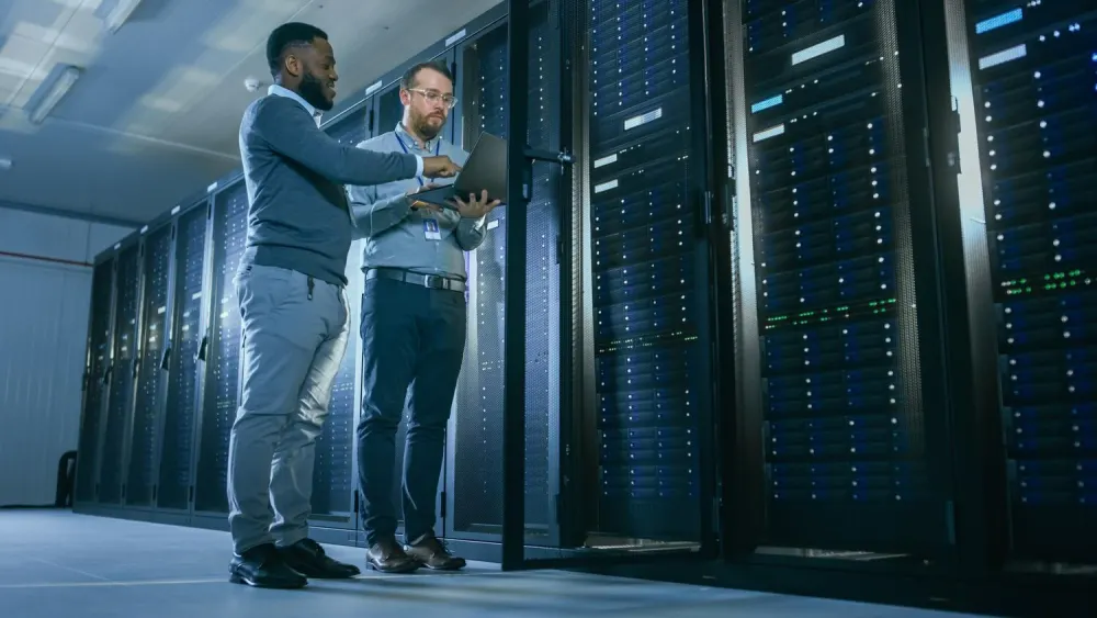 Two IT engineers reviewing systems in a server room
